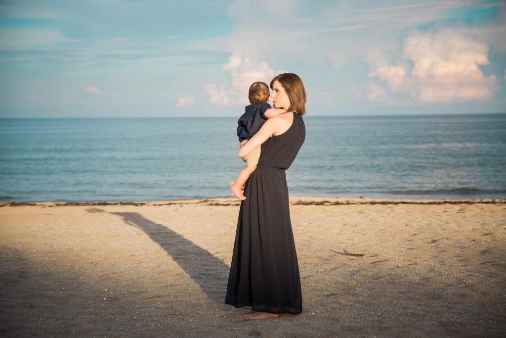 Rebekah holding her son at the beach